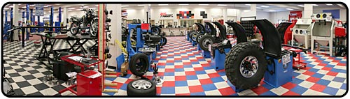 Our tire changer area in our showroom displays a variety of tire changers. Also shown in picture are our folding engine crane, parts washer, motorcycle lifts, and transmission jacks.